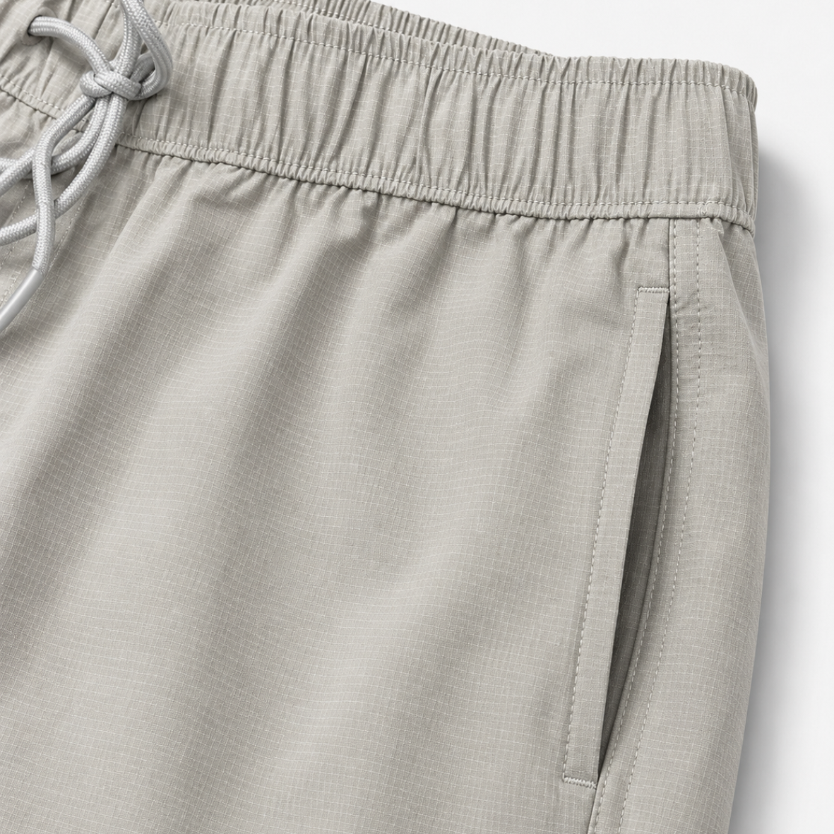 Close-up of light gray shorts with drawstring on a white background
