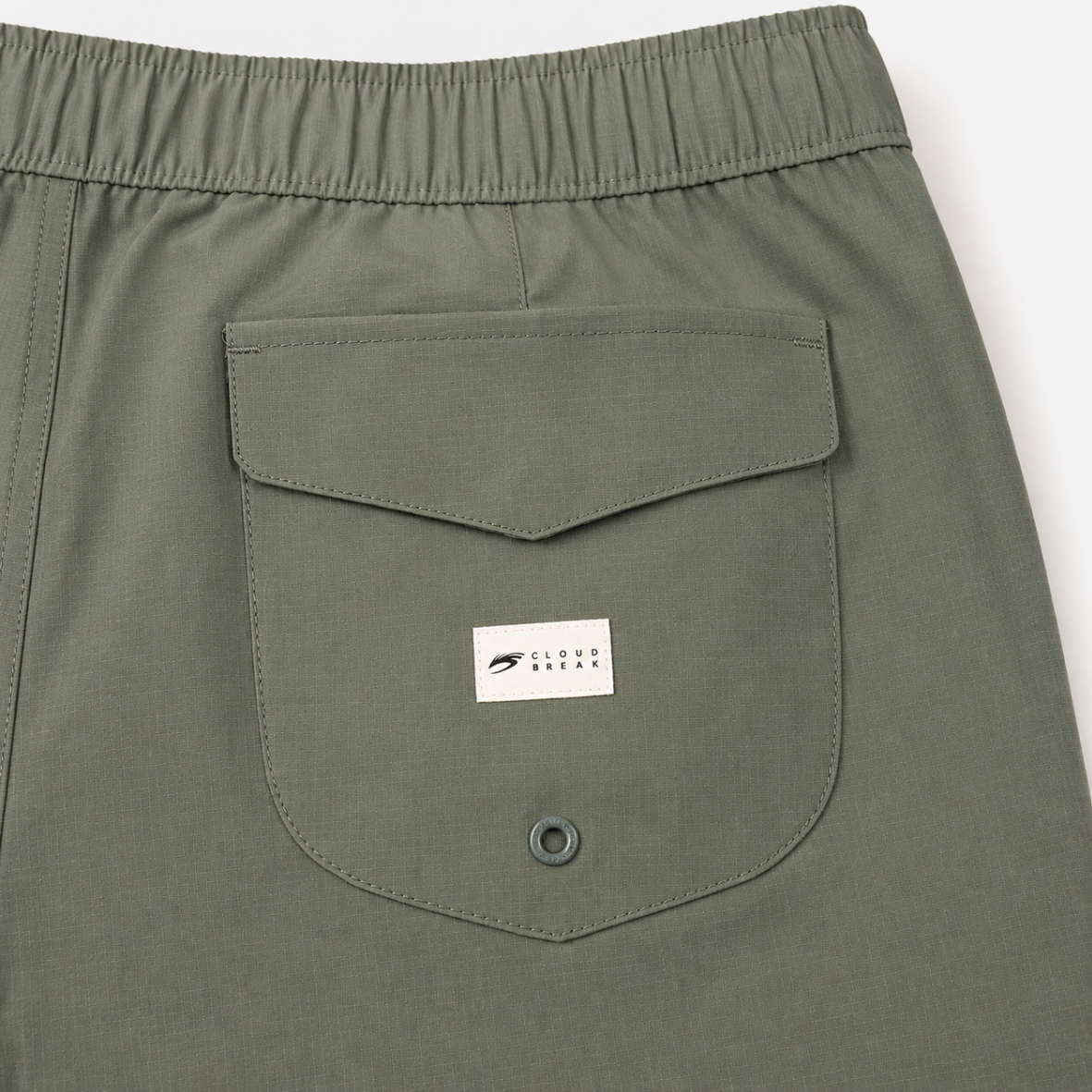 Close-up of green shorts with a pocket and brand logo on a white background